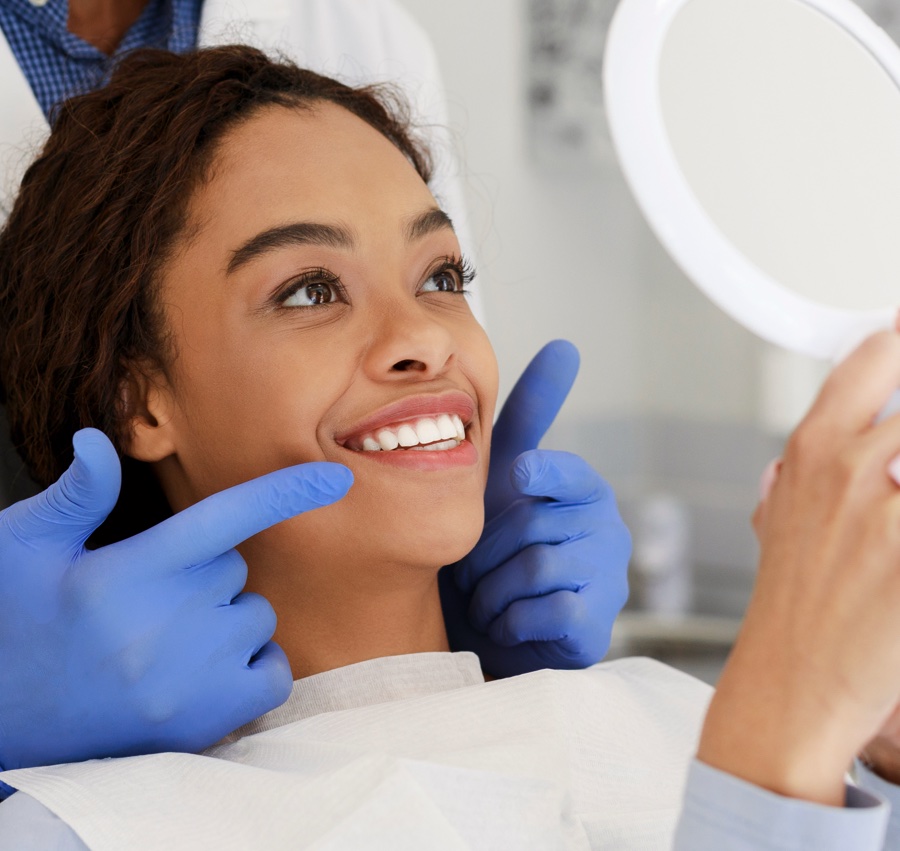 Patient examining smile with orthodontist in braces tigard, Invisalign tigard.