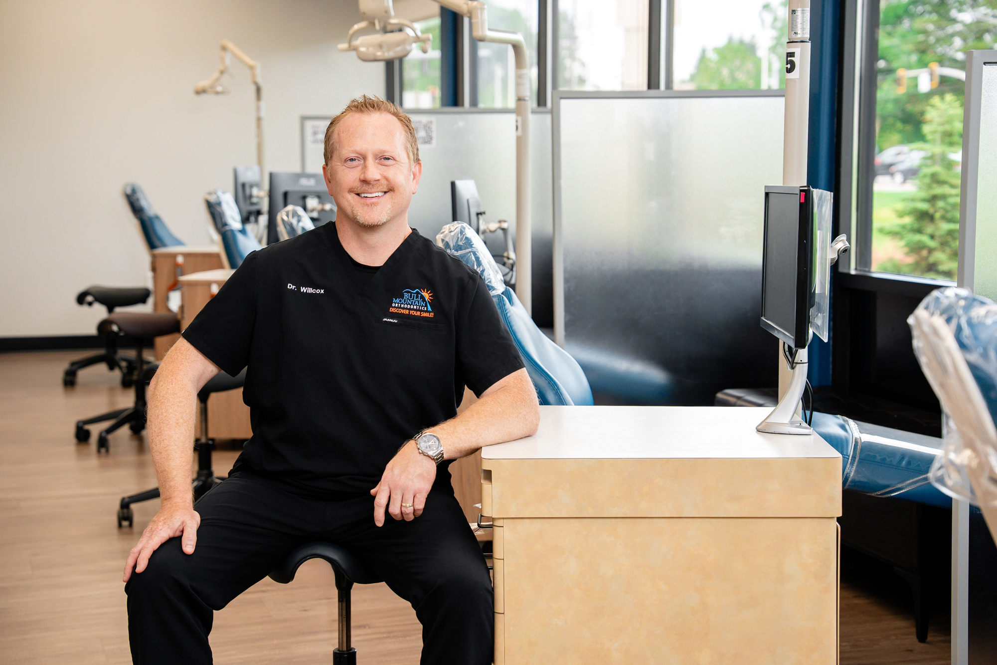 Dr. Bryce Willcox smiling in the treatment area at Bull Mountain Orthodontics in Tigard, OR.